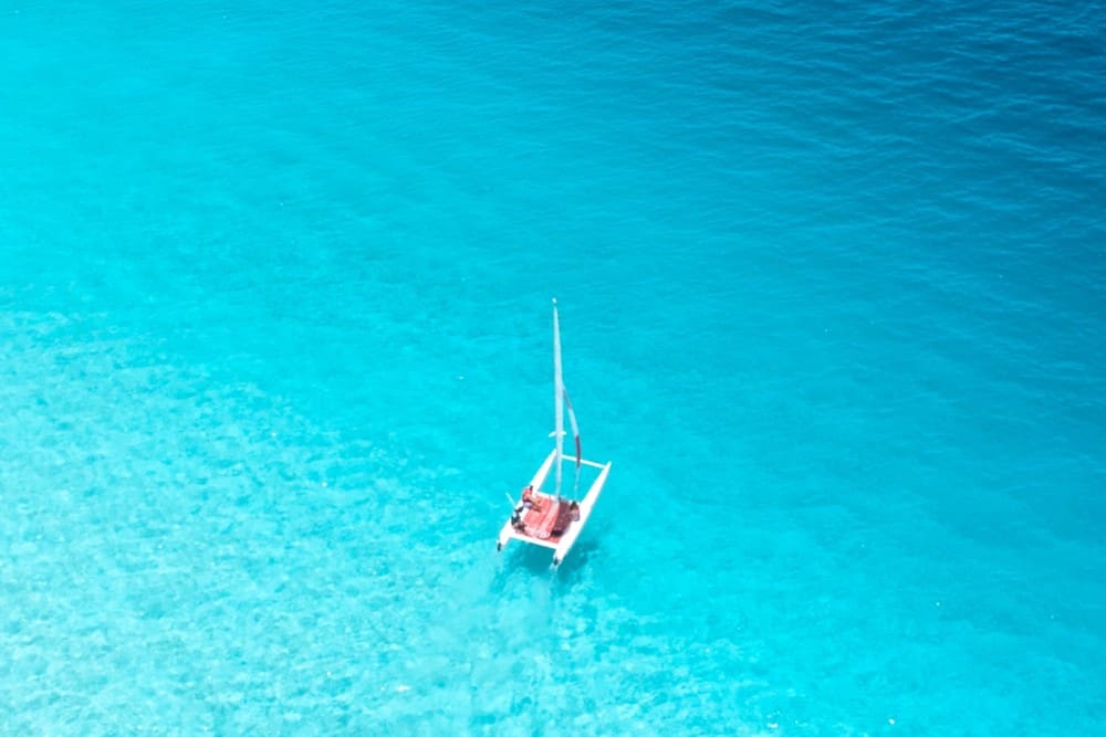 Eine Luftaufnahme eines Segelboots, das im klaren blauen Wasser in der Nähe von Baros auf den Malediven schwimmt.