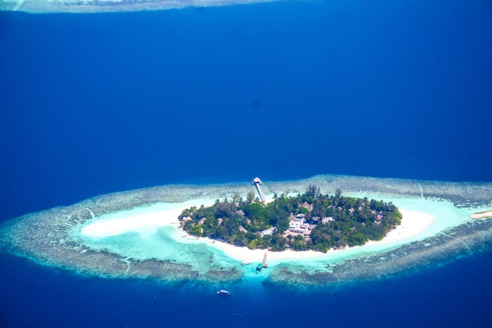 Eine Luftaufnahme einer Insel mitten im Ozean, genauer gesagt auf den Malediven.
