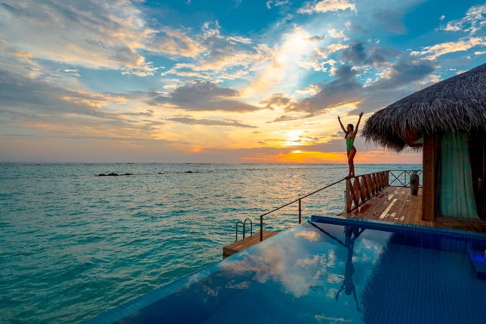 Ein Infinity-Pool mit Blick auf das Meer bei Sonnenuntergang auf den Malediven.